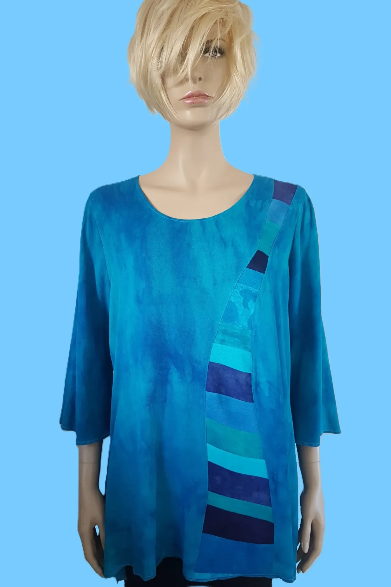 Turquoise blouse met ronde patchwork baan